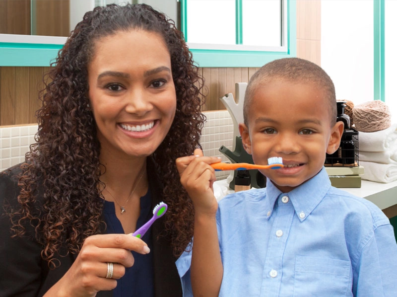 Mother and son brushing their teeth in the bathroom.