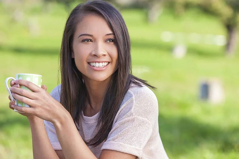 Woman Smiling & Drinking Coffee